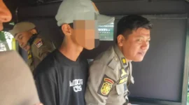 Personil Satpol PP Padang mengamankan seorang pemuda yang beraktivitas sebagai pak ogah di kawasan Simpang UNP depan Batalyon, Selasa (19/5/2026). (Foto: Humas Satpol PP Padang)