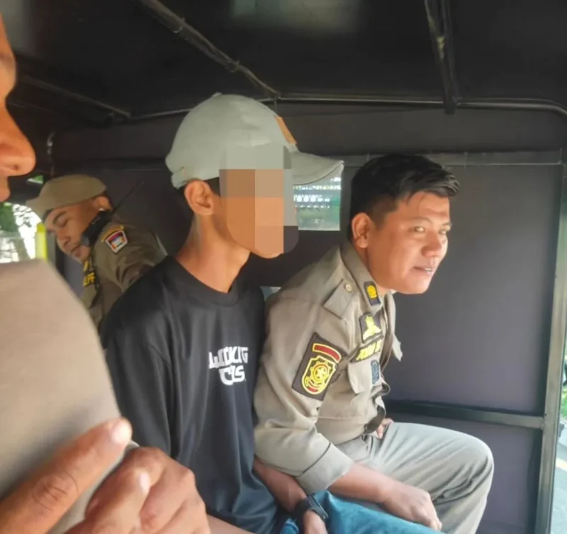 Personil Satpol PP Padang mengamankan seorang pemuda yang beraktivitas sebagai pak ogah di kawasan Simpang UNP depan Batalyon, Selasa (19/5/2026). (Foto: Humas Satpol PP Padang)