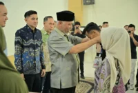 Gubernur Sumbar Mahyeldi memasangkan kokarde kepada peserta pelatihan digital marketing di Auditorium II Mifan Resort and Water Park, Padang Panjang, Minggu (24/5/2026). (Foto: ADPSB)