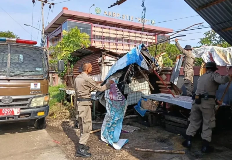 Petugas Satpol PP Padang membongkar pos ronda yang dijadikan pangkalan ojek dan lapak PKL di Simpang Jalan Pramuka, Jalan Khatib Sulaiman, Kecamatan Padang Utara, Senin (11/5/2026). (Foto: Humas Satpol PP Padang)