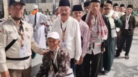 Petugas Kloter PDG 06 Embarkasi Padang mendampingi jemaah haji menuju Masjidil Haram. (Foto: Humas Kemenhaj Sumbar)