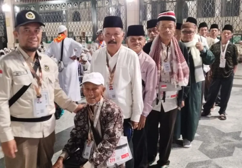 Petugas Kloter PDG 06 Embarkasi Padang mendampingi jemaah haji menuju Masjidil Haram. (Foto: Humas Kemenhaj Sumbar)