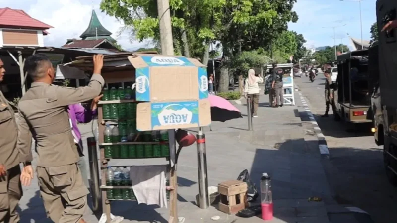 Personil Satpol PP Padang menertibkan lapak PKL yang berjualan di trotoar, Kamis (21/5/2026) siang. (Foto: Humas Satpol PP Padang)