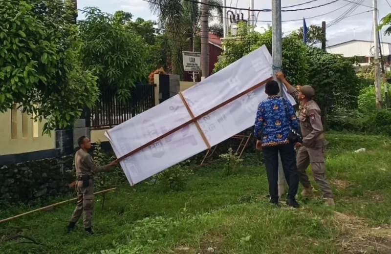 Personil Satpol PP Padang menertibkan baliho di kawasan Jalan Bypass, Kecamatan Kuranji, Rabu (20/5/2026). (Foto: Humas Satpol PP Padang)