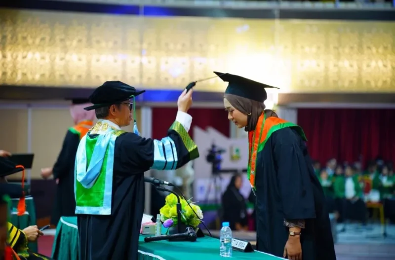 Rektor Unand, Efa Yonnedi, Ph.D memindahkan jambul wisudawati pada Wisuda II Tahun 2026 di Auditorium Kampus Limau Manis. (Foto: Humas Unand)