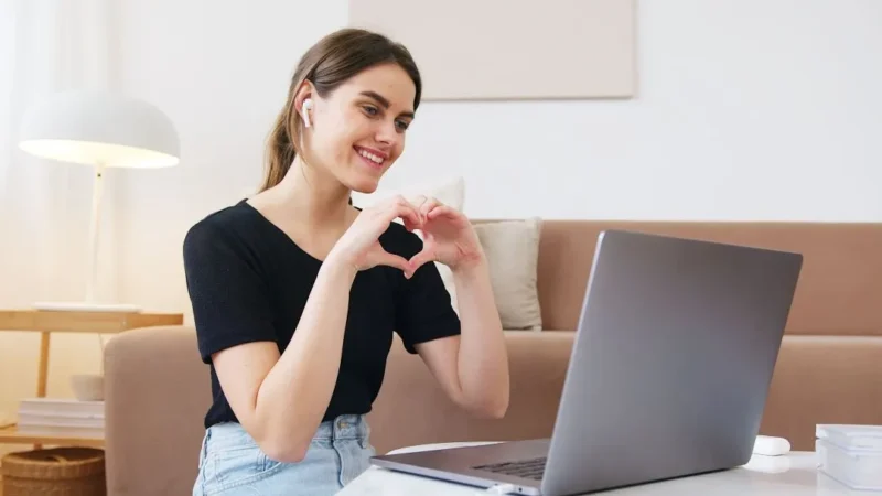 Seorang wanita muda tersenyum saat melakukan panggilan video. (Foto: Pexels)