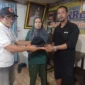 Ketua KSB Kecamatan Padang Selatan, Benny Abeng Law menyerahkan seragam kepada 60 anggota KSB. (Foto: BPBD Padang)
