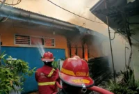 Personel Dinas Damkar Padang berjibaku memadamkan api yang membakar rumah di Kampung Jao Dalam, Kelurahan Kampung Jao, Kecamatan Padang Barat, Kota Padang, Jumat (12/6/2026) sore. (Foto: Dinas Damkar Padang)