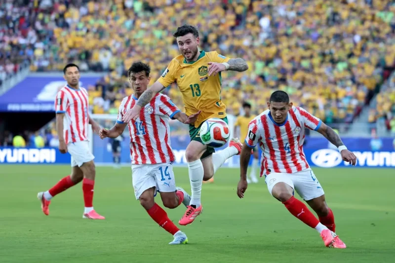 Pemain Timnas Australia berduel memperebutkan bola dengan pemain Timnas Paraguay dalam laga terakhir Grup D Piala Dunia 2026. (Foto: FIFA.com)