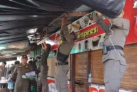 Petugas Satpol PP Padang menertibkan warung yang berdiri di atas trotoar di Kecamatan Padang Utara, Jumat (5/6/2026). (Foto: Humas Satpol PP Padang)