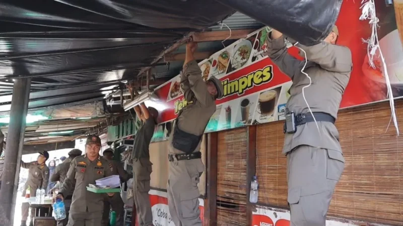 Petugas Satpol PP Padang menertibkan warung yang berdiri di atas trotoar di Kecamatan Padang Utara, Jumat (5/6/2026). (Foto: Humas Satpol PP Padang)