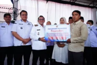 Bupati Tanah Datar Eka Putra menyerahkan bansos dan BLT kepada korban bencana hidrometeorologi di Gedung Indo Jolito Batusangkar, Rabu (3/6/2026). (Foto: Prokopim Tanah Datar)