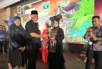 Gubernur Sumbar Mahyeldi menyerahkan piala kepada pemenang lomba. (Foto: ADPSB)