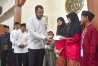 Wali Kota Padang Fadly Amran menyerahkan reward kepada peserta Subuh Mubarakah Program Smart Surau di Masjid As Salam, Komplek Dangau Teduh, Minggu (7/6/2026). (Foto: Pemko Padang)