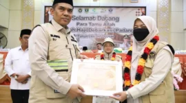 Kepala Kantor Wilayah Kemenhaj Sumbar menyerahkan penghargaan kepada petugas haji atas dedikasi dalam melayani Jemaah. (Foto: Kemenhaj Sumbar)