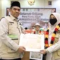 Kepala Kantor Wilayah Kemenhaj Sumbar menyerahkan penghargaan kepada petugas haji atas dedikasi dalam melayani Jemaah. (Foto: Kemenhaj Sumbar)