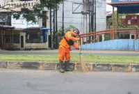 Petugas kebersihan menyapu sampah yang berserakan di salah satu ruas jalan di Padang. (Foto: Pemko Padang)