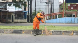 Petugas kebersihan menyapu sampah yang berserakan di salah satu ruas jalan di Padang. (Foto: Pemko Padang)
