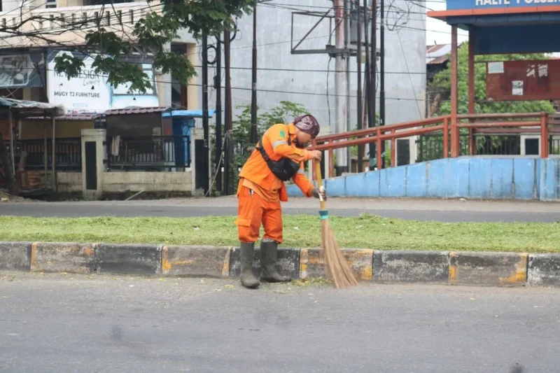 Petugas kebersihan menyapu sampah yang berserakan di salah satu ruas jalan di Padang. (Foto: Pemko Padang)