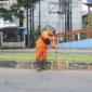 Petugas kebersihan menyapu sampah yang berserakan di salah satu ruas jalan di Padang. (Foto: Pemko Padang)