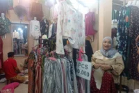 Pedagang menunjukkan koleksi pakaian yang dijual di Pasar Raya Padang Fase VII. (Foto: Diskominfo Padang)