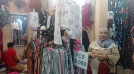 Pedagang menunjukkan koleksi pakaian yang dijual di Pasar Raya Padang Fase VII. (Foto: Diskominfo Padang)