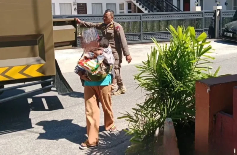 Petugas Satpol PP Padang mengamankan seorang pengemis sambil membawa seorang anak di kawasan lampu merah Jalan Imam Bonjol, Kamis (4/6/2026). (Foto: Humas Satpol PP Padang)