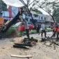 TRC BPBD Padang membersihkan material pohon tumbang di Jalan Raya Padang-Solok, Kelurahan Bandar Buat, Kecamatan Lubuk Kilangan, Kamis (11/6/2026). (Foto: Pusdalops BPBD Padang)