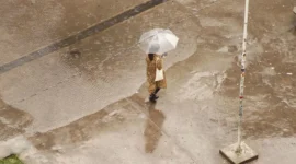 Ilustrasi seorang wanita berpayung sedang berjalan saat hujan turun. (Foto: Pexels)