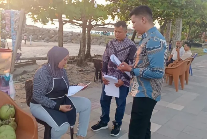 Pegawai Dispar Padang membagikan surat pemberitahuan sekaligus imbauan kepada pedagang di kawasan Pantai Padang. (Foto: Dispar Padang)