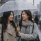 Dua orang wanita berpayung saat hujan. (Foto: AI Generate)
