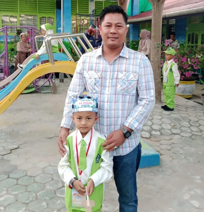 Eko Syafrino mendampingi putranya Zahid Hamizan Rabbani mengikuti hari pertama sekolah di RA Ikhlas Gunung Pangilun, Kota Padang, Senin (13/7/2026).