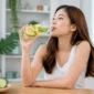 Ilustrasi seorang wanita sedang menikmati infused water. (Foto: AI Generate)