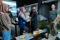 Kepala Dinas Perkim Padang Tri Hadiyanto menyerahkan bantuan beras kepada warga Huntara Lubuk Buaya. (Foto: Pemko Padang)