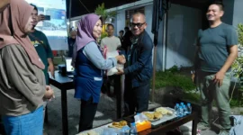 Kepala Dinas Perkim Padang Tri Hadiyanto menyerahkan bantuan beras kepada warga Huntara Lubuk Buaya. (Foto: Pemko Padang)