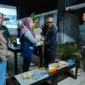 Kepala Dinas Perkim Padang Tri Hadiyanto menyerahkan bantuan beras kepada warga Huntara Lubuk Buaya. (Foto: Pemko Padang)