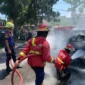 Petugas Damkar Padang memadamkan api yang membakar mobil Honda Freed di depan McDonald's Ahmad Yani Padang, Jumat (24/7/2026). (Foto: Dinas Damkar Padang)