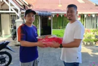 Kepala Bagian Persidangan DPRD Provinsi Sumbar, Dahrul Idris menyerahkan bantuan bendera Merah Putih. (Foto: Ist)