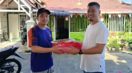 Kepala Bagian Persidangan DPRD Provinsi Sumbar, Dahrul Idris menyerahkan bantuan bendera Merah Putih. (Foto: Ist)