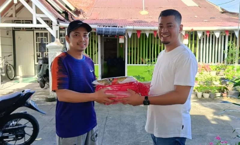 Kepala Bagian Persidangan DPRD Provinsi Sumbar, Dahrul Idris menyerahkan bantuan bendera Merah Putih. (Foto: Ist)