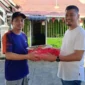 Kepala Bagian Persidangan DPRD Provinsi Sumbar, Dahrul Idris menyerahkan bantuan bendera Merah Putih. (Foto: Ist)