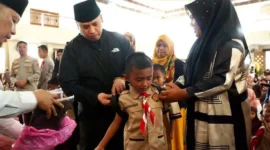 Wali Kota Padang Panjang Hendri Arnis menyerahkan paket seragam sekolah gratis secara simbolis kepada siswa di Masjid Manarul 'Ilmi Islamic Centre, Rabu (22/7/2026). (Foto: Diskominfo Padang Panjang)