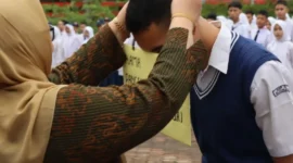 Kepala SMK SMAK Padang, Silvania Lorina memasangkan kokarde kepada peserta tanda dibukanya MPLS, Kamis (9/7). (Foto: Humas SMK SMAK Padang)