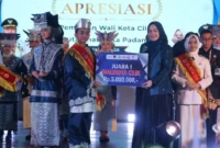 Ketua TP PKK Padang, Dian Puspita Fadly Amran menyerahkan hadiah kepada juara 1 Pilwadu Padang 2026. (Foto: Pemko Padang)