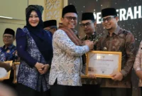 Sekretaris Jenderal Kemenhaj RI, Teguh Dwi Nugroho menyerahkan penghargaan di Asrama Haji Padang, Jumat (31/7). (Foto: Kemenhaj Sumbar)
