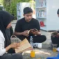 Sejumlah pengunjung sedang membaca buku di Taman bacaan terbuka Kantor Dispusip Padang, Sabtu (25/7/2026). (Foto: Pemko Padang)
