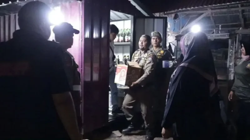 Petugas Satpol PP Padang mengamankan minuman beralkohol tanpa izin dari sebuah warung. (Foto: Humas Satpol PP Padang)