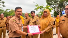 Asisten II Setdako Padang Bidang Perekonomian dan Pembangunan Didi Aryadi menyerahkan penghargaan kepada ASN. (Foto: Pemko Padang)
