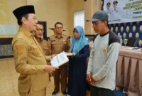 Wali Kota Payakumbuh Zulmaeta menyerahkan bantuan peningkatan kualitas RTLH kepada penerima, Selasa (11/8/2026). (Foto: MC Payakumbuh)