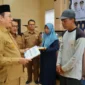 Wali Kota Payakumbuh Zulmaeta menyerahkan bantuan peningkatan kualitas RTLH kepada penerima, Selasa (11/8/2026). (Foto: MC Payakumbuh)